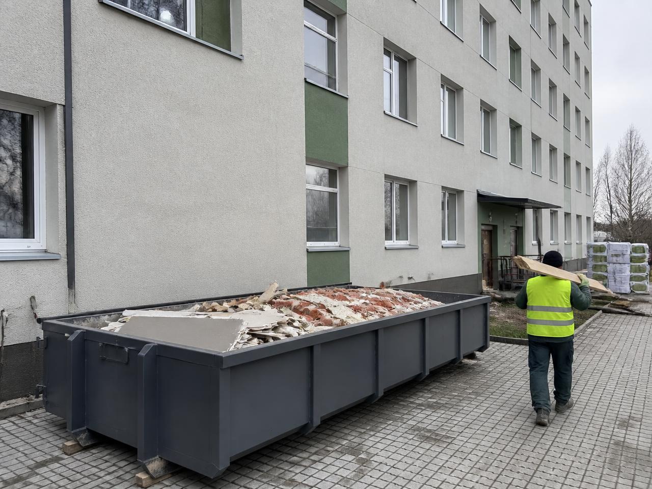 Ehitusjäätmete konteiner ehitusobjektil kortermaja hoovis, konteineris tellise- ja kipsplaadijäätmed